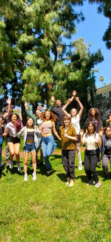 CASSI 2023 interns jump on the grass at the Observatories campus. 