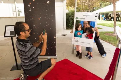 Family poses on the redshift carpet at the Carnegie Observatories Open House