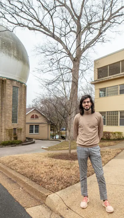 Julien Rojas stands outside on the Broad Branch Road campus